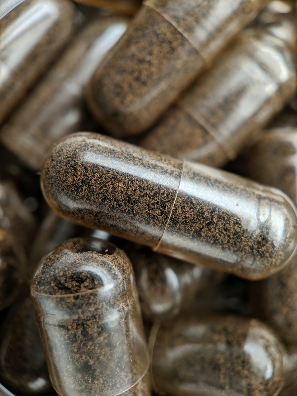 Macro of clear capsules filled with brown powder
