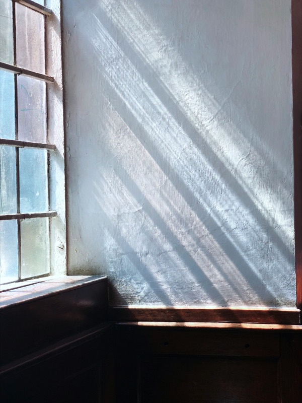 Sunlight streaming through a window onto a white wall